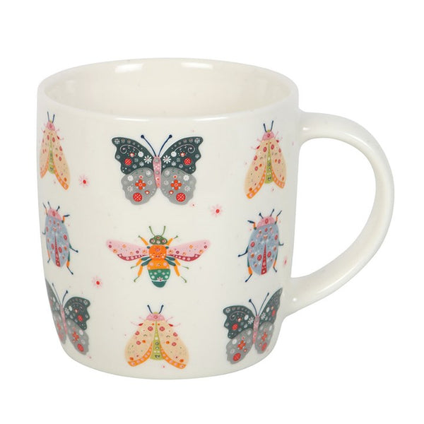 White mug with colorful butterfly and moth design on a white background