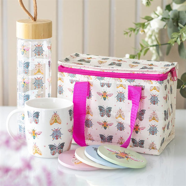 Insulated lunch bag with pink strap paired with ceramic mug featuring floral bug print with butterflies and beetles – Panache Homeware Kitchen Collection, whimsical cottagecore set.
