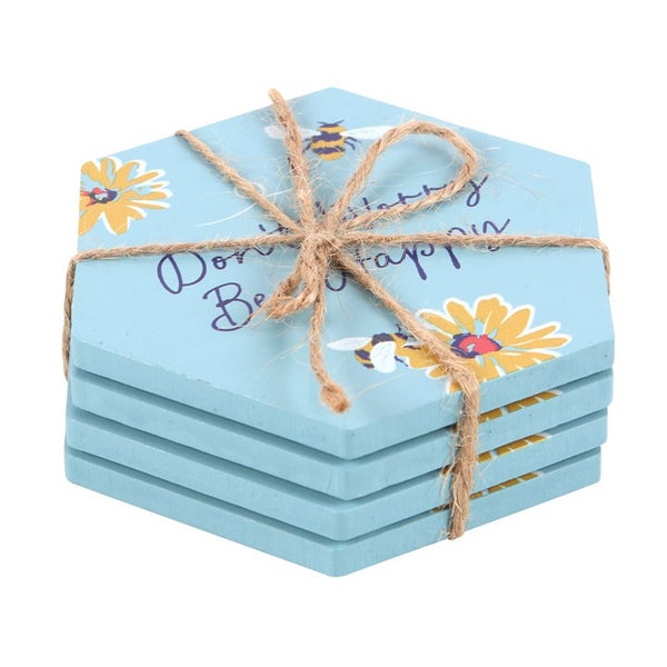 Set of blue hexagonal coasters with floral designs and twine on a white background